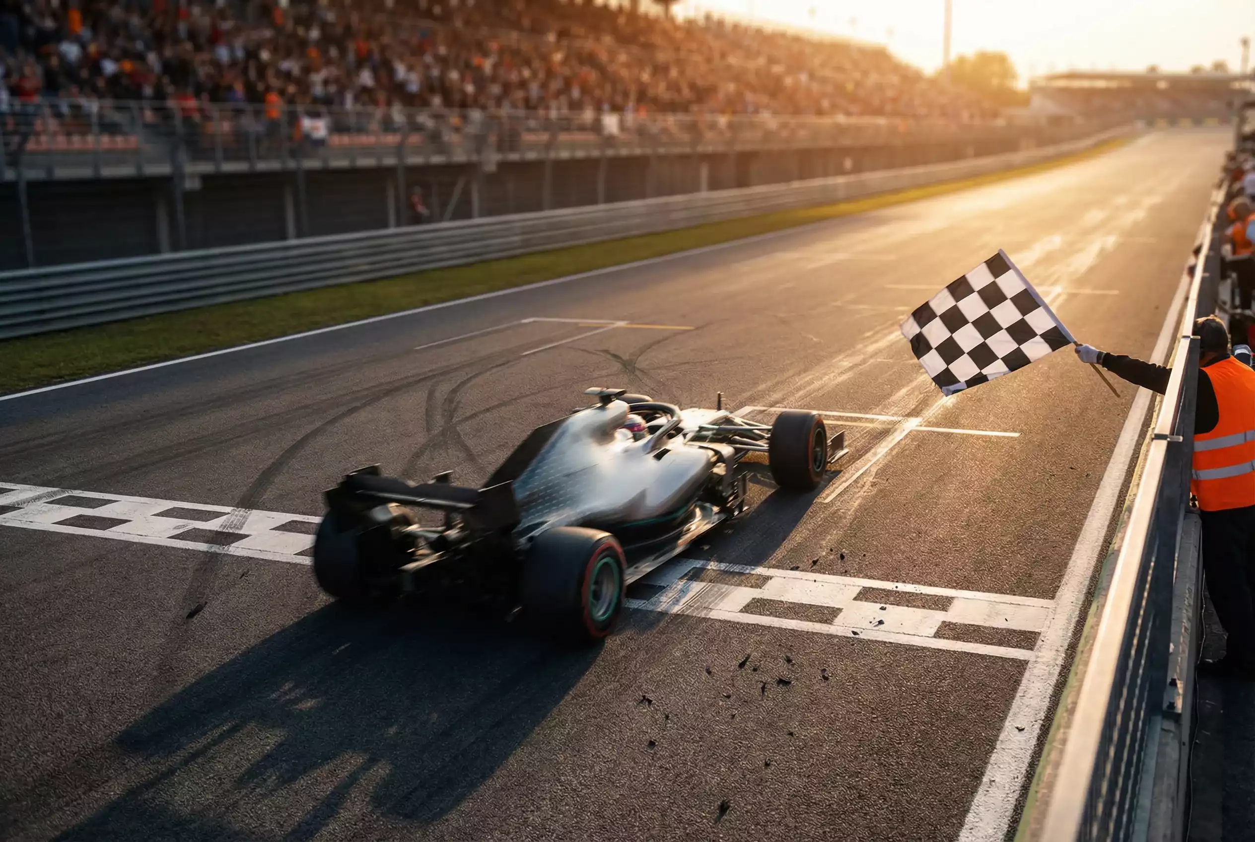 Formel 1 Siegerwette: Rennfahrer überquert die Ziellinie beim Grand Prix